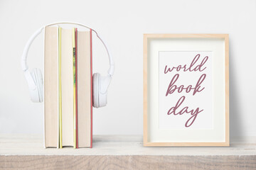 Books and headphones next to a wooden frame with the text World Book Day.