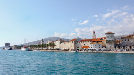Promenade of Trogir town with stone walls and bell tower