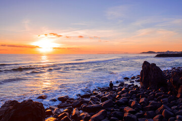 Orange lit sunrise skies over the rocks at Burleigh, Gold Coast, Australia