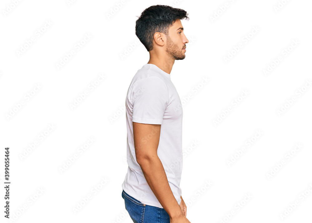 Wall mural young handsome man wearing casual white tshirt looking to side, relax profile pose with natural face