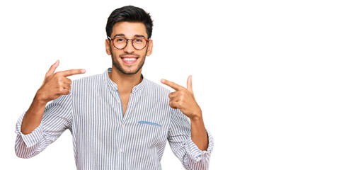 Young handsome man wearing casual clothes and glasses smiling cheerful showing and pointing with...