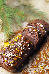 Chocolate cake with chocolate and orange. Christmas tree branches and cones. Christmas log. Festive sweets.