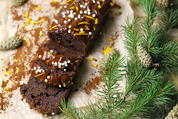 Chocolate cake with chocolate and orange. Christmas tree branches and cones. Christmas log. Festive sweets.