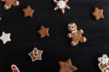 Gingerbread man and stars close up on black background. Traditional pastries