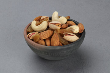 Assorted nuts in a clay bowl. 