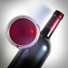 
A glass of red wine and a bottle of wine.