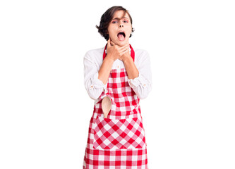 Beautiful young woman with short hair wearing professional cook apron shouting and suffocate...