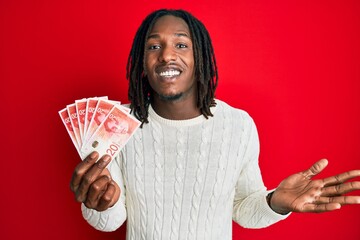 African american man with braids holding 20 israel shekels banknotes celebrating achievement with...