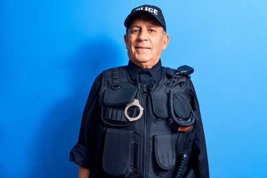 Senior man with grey hair wearing police uniform with a happy and cool smile on face. lucky person.