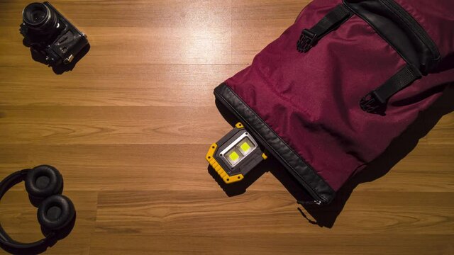 Stop motion animation. Travel set packing into a backpack on wooden  floor. 