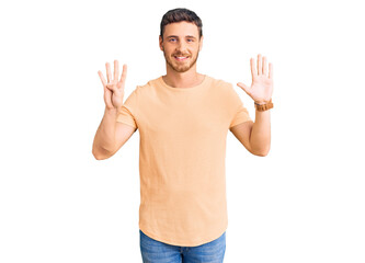 Handsome young man with bear wearing casual yellow tshirt showing and pointing up with fingers...