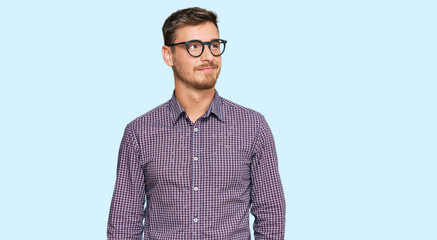 Handsome caucasian man wearing casual clothes and glasses smiling looking to the side and staring...