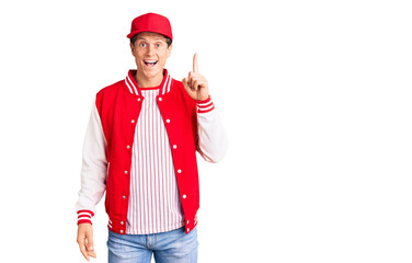 Young handsome man wearing baseball uniform pointing finger up with successful idea. exited and happy. number one.