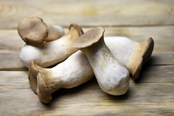 Selective focus. Macro. Raw eringi mushrooms on a wooden surface.