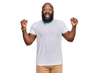 Young african american man wearing casual white tshirt celebrating surprised and amazed for success...
