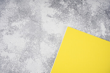 Yellow notebook on light gray concrete background. Colors of the Year 2021, workplace concept. Top view, flat lay, mockup, copy space