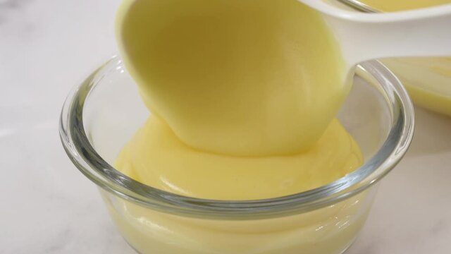 Lemon pudding or lemon curd served with mint leaves and sliced lemon recipe. Serving pudding in a glass bowls