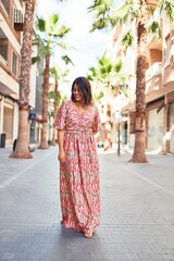 Beautiful young woman wearing fashionable clothes walking down the street