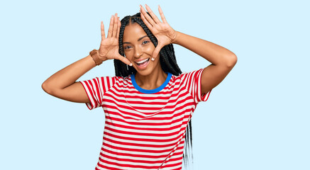 Fototapeta premium Beautiful hispanic woman wearing casual clothes smiling cheerful playing peek a boo with hands showing face. surprised and exited