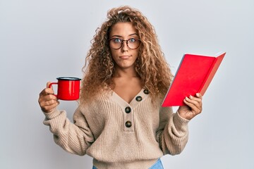 Beautiful caucasian teenager girl reading a book and drinking a cup of coffee skeptic and nervous,...
