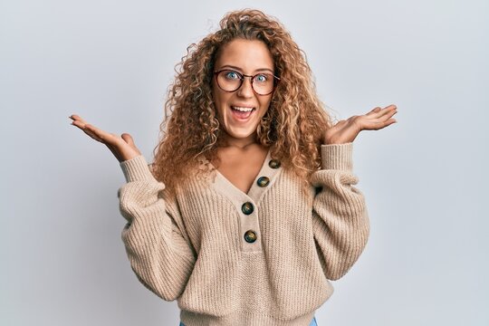 Beautiful caucasian teenager girl wearing casual clothes and glasses celebrating victory with happy smile and winner expression with raised hands