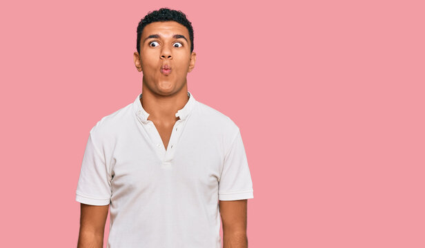 Young arab man wearing casual clothes making fish face with lips, crazy and comical gesture. funny expression.
