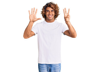 Young hispanic man wearing casual white tshirt showing and pointing up with fingers number eight while smiling confident and happy.