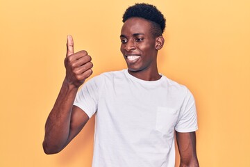 Young african american man wearing casual clothes looking proud, smiling doing thumbs up gesture to the side