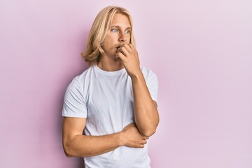 Caucasian young man with long hair wearing casual white t shirt looking stressed and nervous with...
