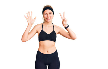 Young beautiful blonde woman wearing sportswear showing and pointing up with fingers number seven while smiling confident and happy.