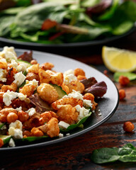 Roasted Cauliflower salad with chickpea, cucumber, greens and feta cheese. healthy food