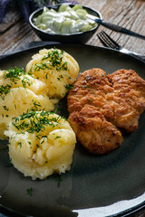 Pork chop served with mashed potatoes and cucumber salad.