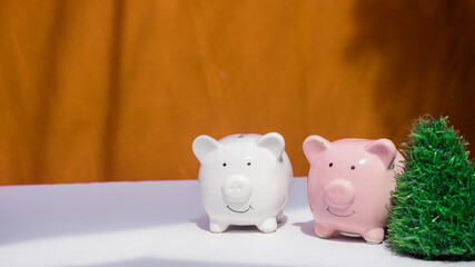 piggy bank in christmas decoration background. christmas tree, light at the back of piggy bank. saving money for holiday break and giving gift for family and friend.