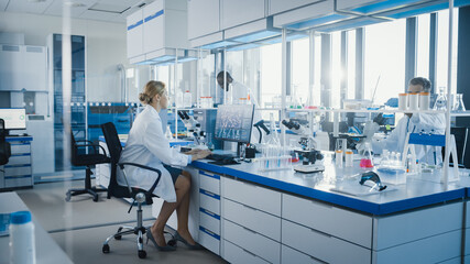 Medical Science Laboratory with Diverse Team of Professional Scientists Working with Microscopes,...