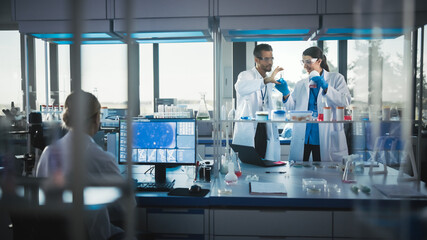 Medical Science and Biotechnology Laboratory with Diverse Team of Research Scientists Working. Microbiologist and Biochemist Talking about Newely Made Test Result. High-Tech Equipment Lab.