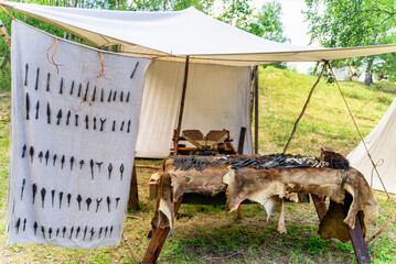 Bowyer, master craftsman workshop with variety of arrowheads and tools in historical reenactment of...