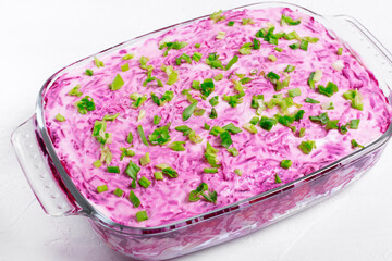 Shuba salad with herring, vegetables and mayonnaise on the white table. Russian food