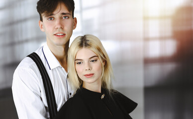 Young couple of businessman and woman are standing in a modern office. Portrait of successful business people