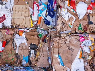 Waste cardboard stacked prior to processing at a recycling plant in UK