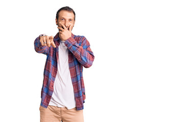 Young handsome man wearing casual clothes laughing at you, pointing finger to the camera with hand over mouth, shame expression