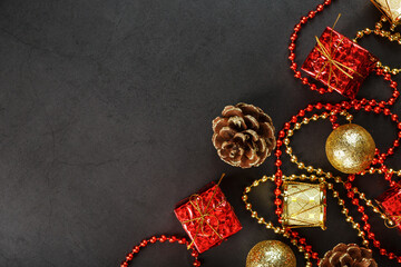 Christmas or New Years dark background with red and gold decorations for the Christmas tree with free space.