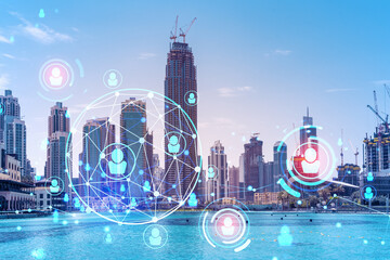 Skyscrapers of Dubai business downtown. International hub of trading and financial services. Social network icons hologram, concept of people connection. Double exposure. Dubai Canal waterfront.