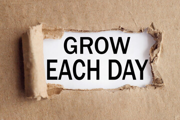 grow each day, text on white paper on torn paper background