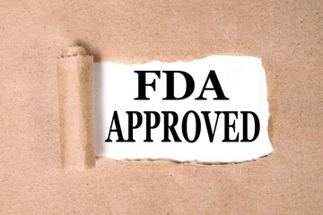 FDA APPROVED, text on white paper on torn paper background