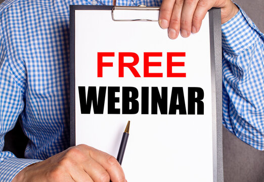 The man points with a pen to the phrase FREE WEBINAR on a white sheet.