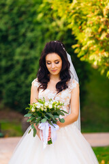 beautiful bride holds wedding bouquet and looks at it. bride on