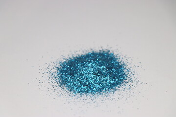 Sparkles which is used in making decorations for christmas. Jewellery sparkles blue color on white background