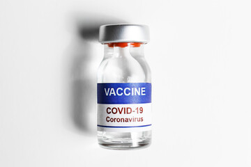 Macro shot of antiviral vaccine vial for immunization against covid-19 virus. Isolated on white background with copy space for text. Close up, top view.