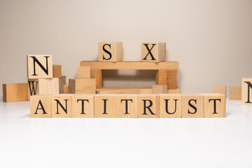 Antitrust. The term economy and trade. Written in wooden cubes.