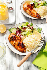 Grilled chicken breast, fillet garnished with couscous and fresh vegetable salad of lettuce, arugula, spinach and cucumber . Healthy lunch menu. Diet food. 